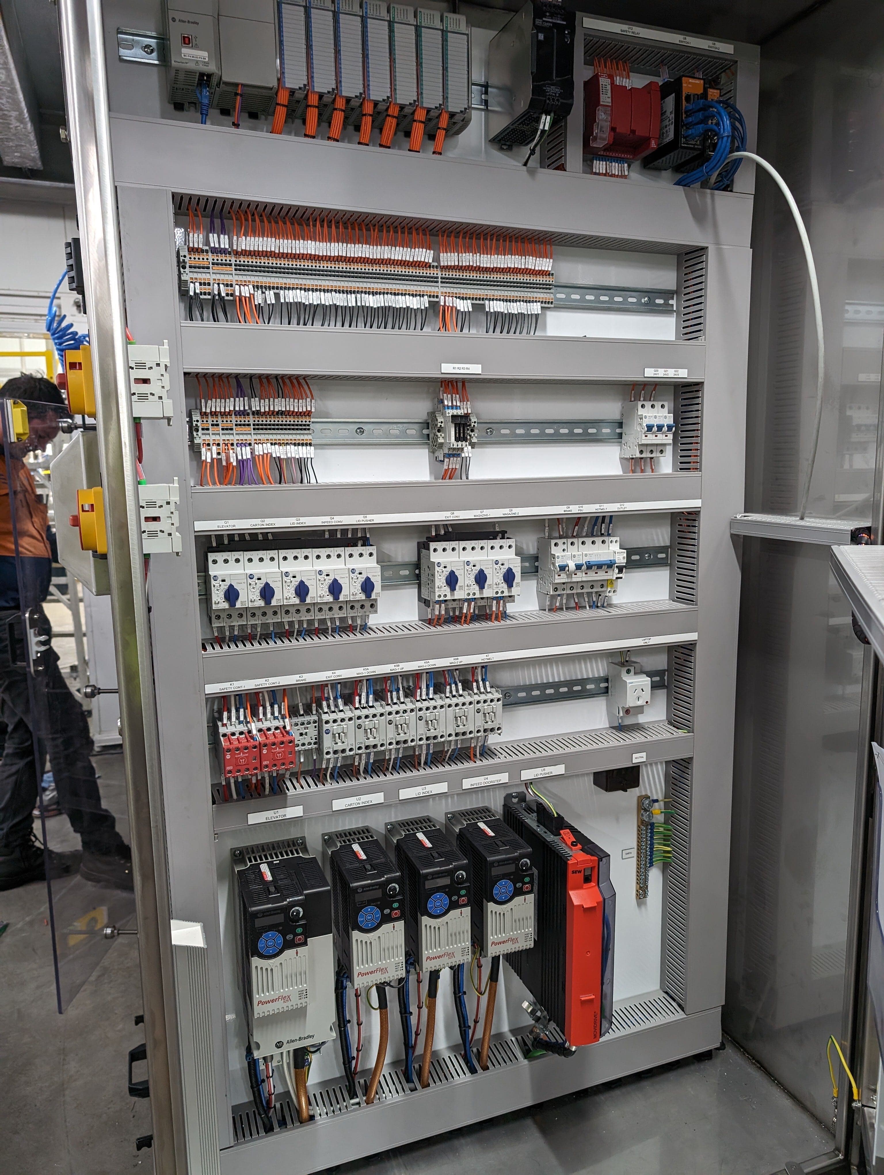 Control panel with Allen-Bradley PLC, PowerFlex drives, safety relays and ferruled terminal rails, every device individually labelled